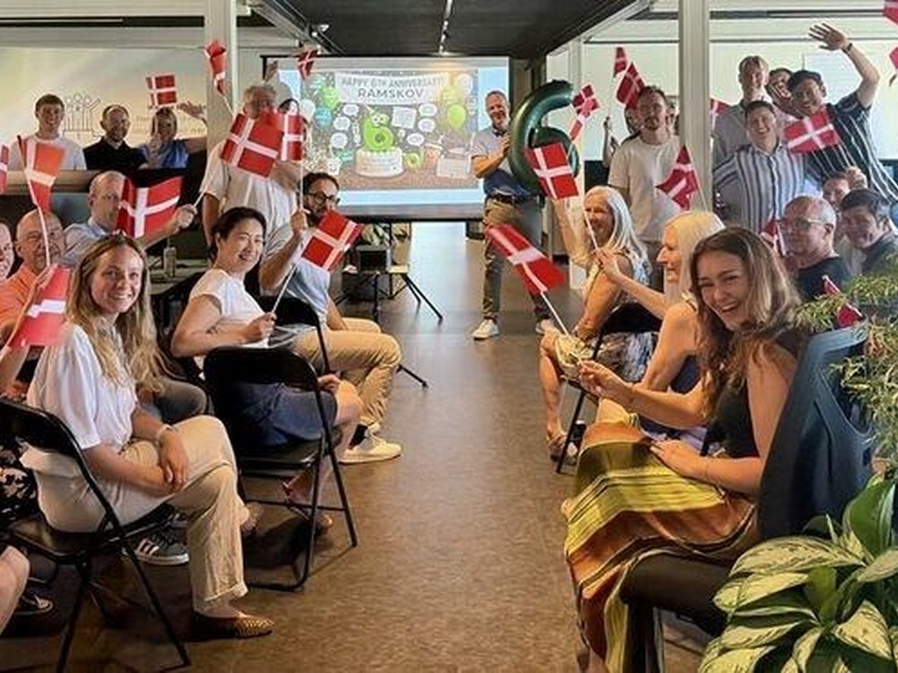 The Ramskov team waving Danish flags at a Happy 6th Anniversary celebration