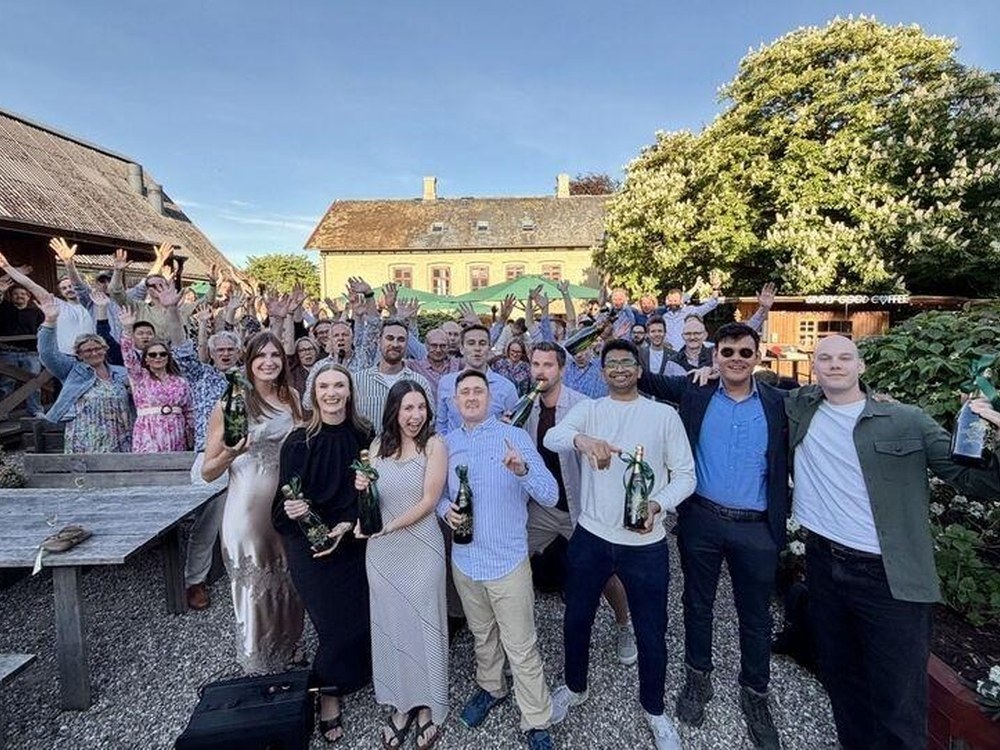 The Ramskov team celebrating with champagne bottles at an outdoor promotion party